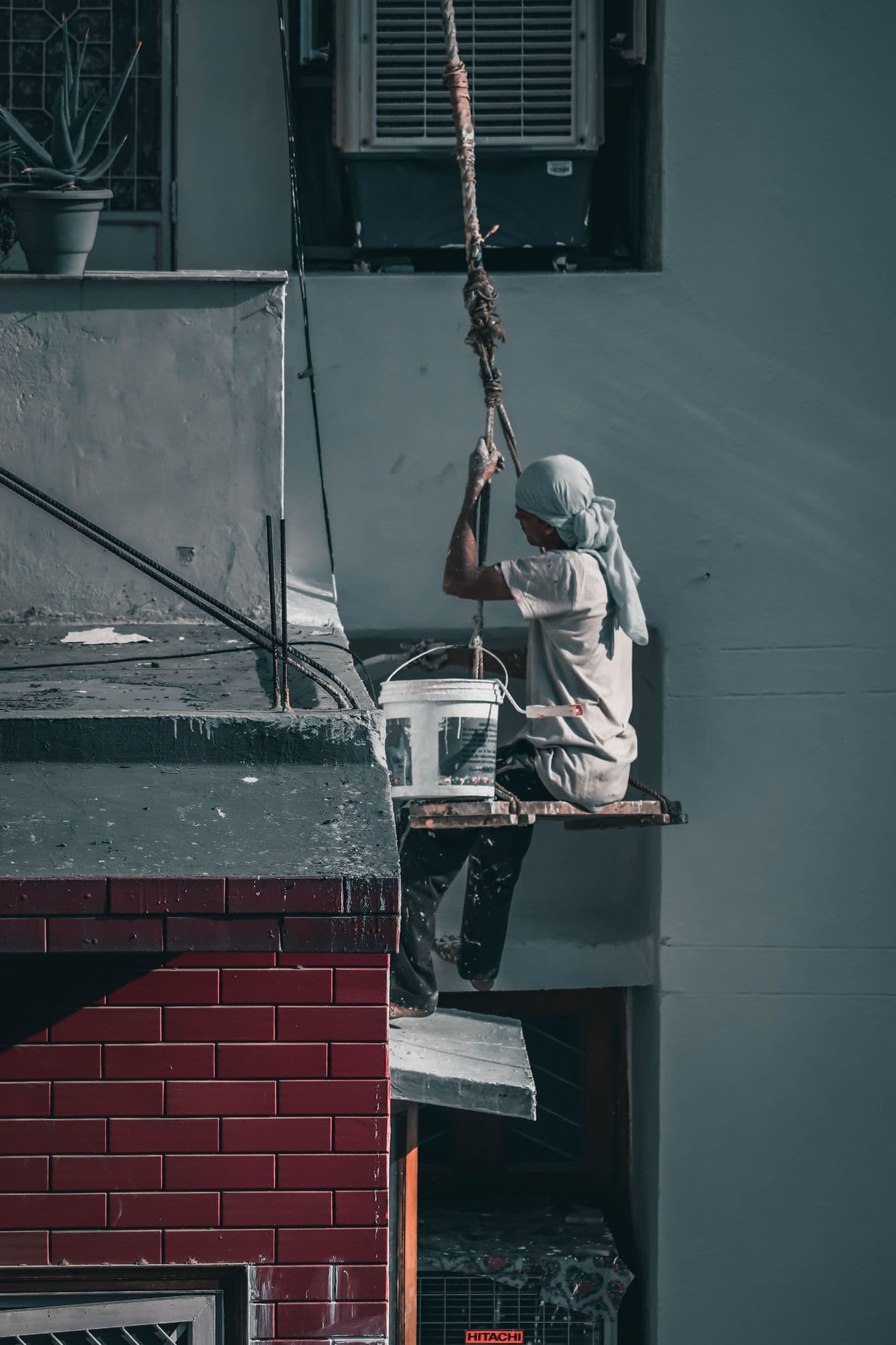 Decorator preparing an exterior elevation from a scaffold